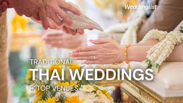 A close-up of the traditional water pouring ceremony at a Thai wedding, with an elder pouring sacred water from a conch shell over the bride's hands decorated with a golden bracelet and flower garlands.