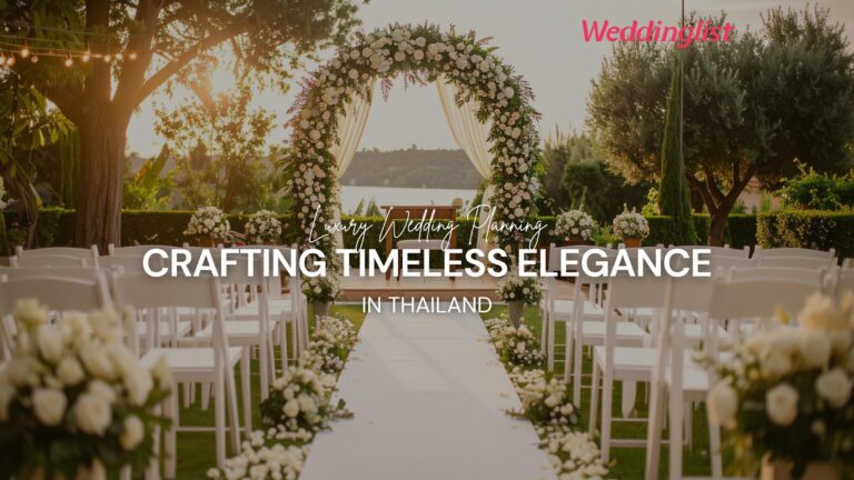 An elegant outdoor high-end wedding ceremony setup in Thailand featuring a floral arch, white chairs, and a scenic background, representing crafting luxury and timeless elegance.