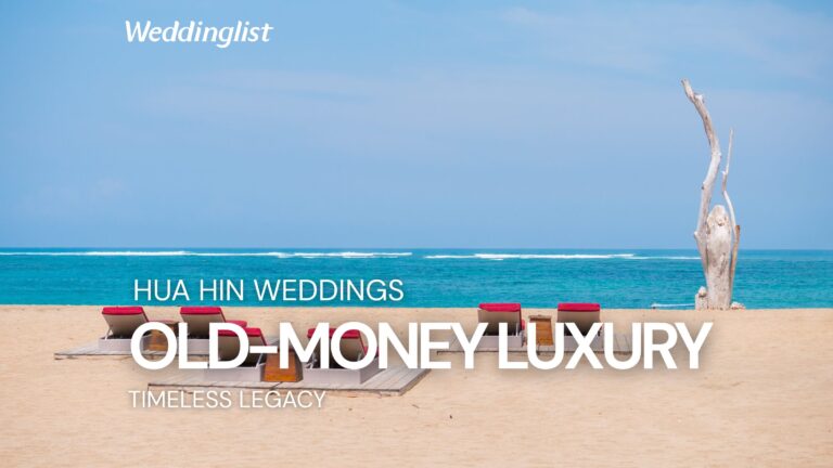 Alt Text: A serene beachfront view in Hua Hin featuring luxurious red-cushioned sun loungers on the sand next to a rustic driftwood sculpture, with the bright blue sea and sky background, featuring a text overlay about old-money luxury Hua Hin weddings.