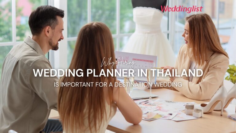 A professional wedding planner in a beige blazer pointing at a calendar during a consultation with an engaged couple, with a white wedding dress mannequin in the background and a text overlay explaining why hiring a wedding planner in Thailand is important for a destination wedding.